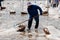 Unidentified Salter or Salted worker using tool scooping salts into wooden baskets pile