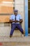 Unidentified Senegalese policeman sits in a chair and looks at