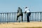 Unidentified Senegalese two men lean on the fence on the coast