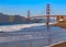 Unidentified surfer at sunset at Baker Beach by the famous Golden Gate Bridge, San Francisco, California, USA