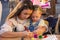 Unidentified teenage girl drawing body art on a hand of little girl