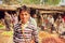 Unidentified teenager standing in crowd of customers of village vegetable market in India