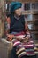 Unidentified Tibetan woman in traditional clothes sit on a bench nearby Jokhang temple