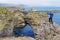 Unidentified tourist standing at Gatklettur Stone Arch,Iceland