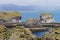 Unidentified tourists standing at the cliff near Gatklettur Stone Arch at Snaefellsnes Peninsula, Iceland