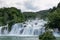 Unidentified tourists swim in waterfall Skradinski Buk of Krka river in Croatia.