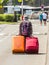 Unidentified traveler walking with two suitcases