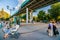 Unidentified unrecognizable people watch Latin dances, conga under Andreevsky pedestrian bridge in Moscow Gorky park