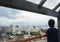 Unidentified woman with a mobile phone looks at the panoramic view of Rio`s downtown