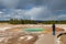 An unidentified woman photographs the Opal Pool