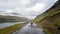 Unidentified woman walking in the dramatic road landscape, Faroe Islands
