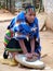 An unidentified woman wears traditional Zulu clothing makes bear with wheat, Shakaland