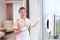 A uniformed maid turns on a window cleaner robot. Photo in the interior. The concept of cleaning and cleanliness. Copy