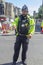 A uniformed police officer on street duty directing tourists close to Windsor Castle which is a famous Royal Residence in Windsor