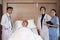 Uniformed professional doctors with male patient in inpatient room of hospital