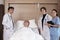 Uniformed professional doctors with male patient in inpatient room of hospital