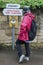 Unindentified woman looking at signs with directions in the Cotswold village of Stanway, Gloucestershire, Cotswolds, UK