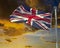 Union Jack on flagpole under dark brooding sky.