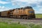 Union Pacific locomotive 8135 heads eastbound with a train with coal loaded hoppers with helper Union Pacific diesel locomotive