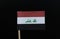 A unique flag of Iraq on toothpick on black background. A horizontal tricolour of red, white, and black, charged with the text in