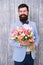 Unique flower arrangements. Spring gift. Bearded man hipster with flowers. Flower for March 8. Love date. international