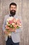 Unique flower arrangements. Spring gift. Bearded man hipster with flowers. Flower for March 8. Love date. international