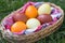 Unique hand painted Easter eggs in basket on grass.