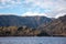 Unique horizontal view from a boat in the middle of a lake with calm water and a snow-capped mountain in the background