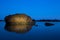 Uniquely lit, dramatic rocky island in a tranquil sea