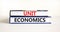 Unit economics symbol. Concept words Unit economics on books. Beautiful white table white background. Business and unit economics