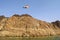 United Arab Emirates flag waving on top of a hill in the Middle of Hatta lake on blue sky background.