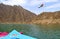 United Arab Emirates flag waving on top of a hill in the Middle of  Hatta lake with two colorful kayaks on a foreground