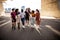 United group of multiracial young friends walking together on city street