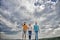 United group purposefully moves forward. Men and woman walks dramatic cloudy sky background. True friendship grow with