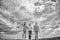 United group purposefully moves forward. Men and woman walks dramatic cloudy sky background. True friendship grow with