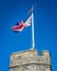 United Kingdom Union Jack flag blowing in the wind on top of Westgate Towers, Canterbury, England.