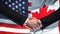 United States and Canada handshake, international friendship, flag background