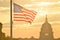 United States Capitol building and US flag silhouette at sunrise, Washington DC