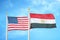 United States and Egypt two flags on flagpoles and blue cloudy sky