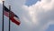 United States Flag and Mississippi State Flag against blue sky with clouds