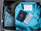 United States passport book with Covid 19 vaccination card and smartphone inside of travel suitcase packed with clothes