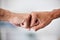 United in victory and success, achieving goals by working together as a community. Closeup of business men fist bumping