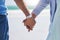 Unity, love and couple holding hands at a beach with trust, solidarity and commitment in nature. Hand, care and man with