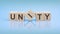 unity - word is written on wooden cubes on a bright blue background. close-up of wooden elements