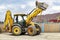 The universal backhoe loader lifted up the bucket on the construction site. Rental of construction equipment for earthworks.