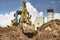 A universal excavator is working on a construction site against a cloudy sky. Earthworks at a construction site. Modern