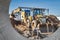 A universal excavator is working on a construction site against a cloudy sky. Earthworks at a construction site. Modern