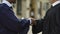 University Chancellor giving diploma to graduate student shaking hand, close up