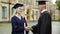 University chancellor giving diploma to student, congratulating and shaking hand