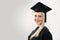 University graduate wearing cap and gown on gray background